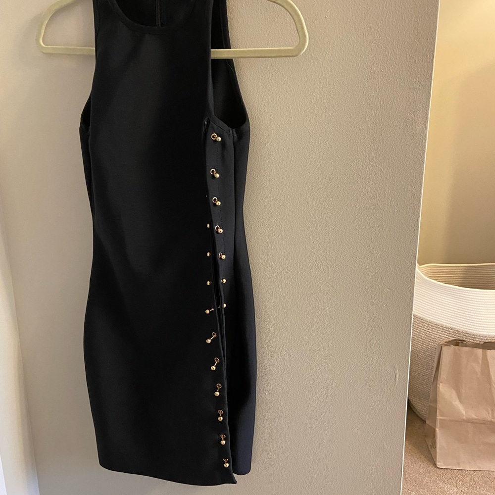 Fashion Nova size XS black dress with gold pin detail on the side.